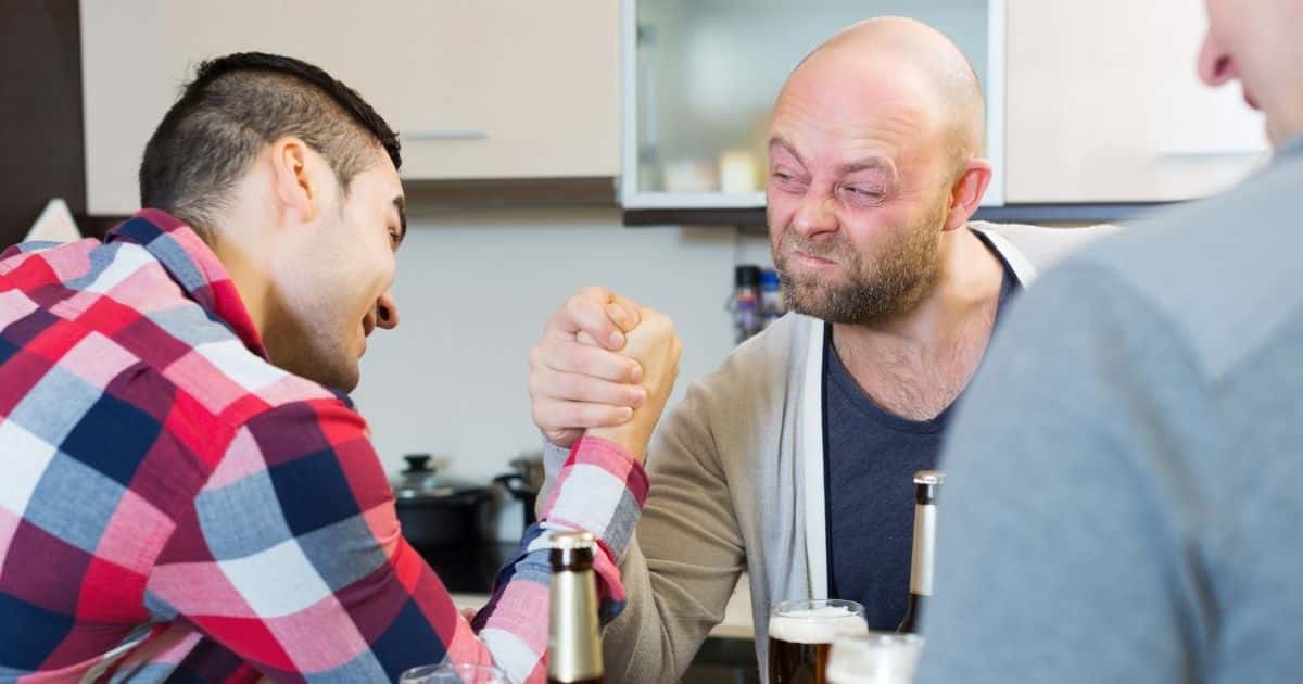 Men arm wrestling at a table
