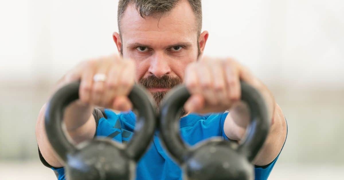 Man exercising with kettlebells