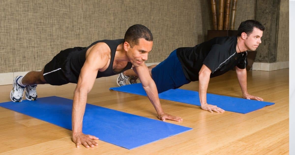 Two men doing push-ups on exercise mats