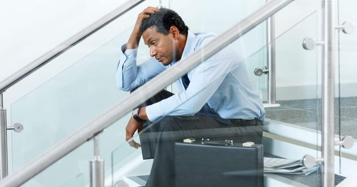 Stressed businessman sitting on stairs
