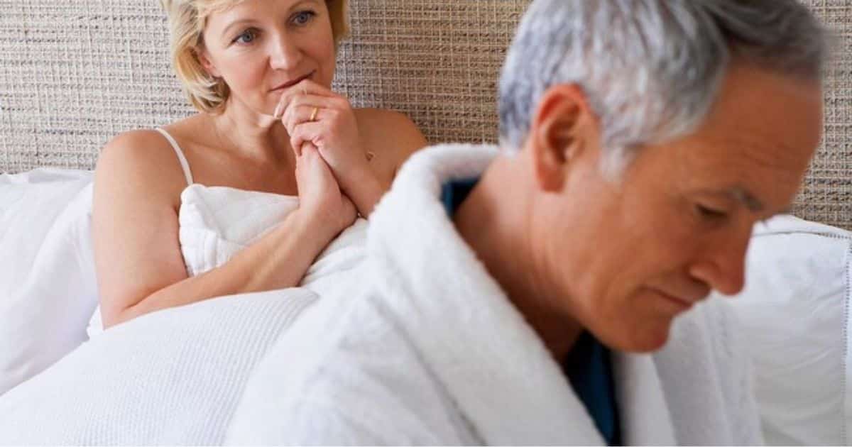 Couple in bed with man turned away