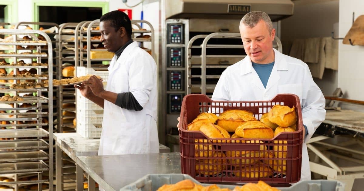 Workers handling oranges in a food facility