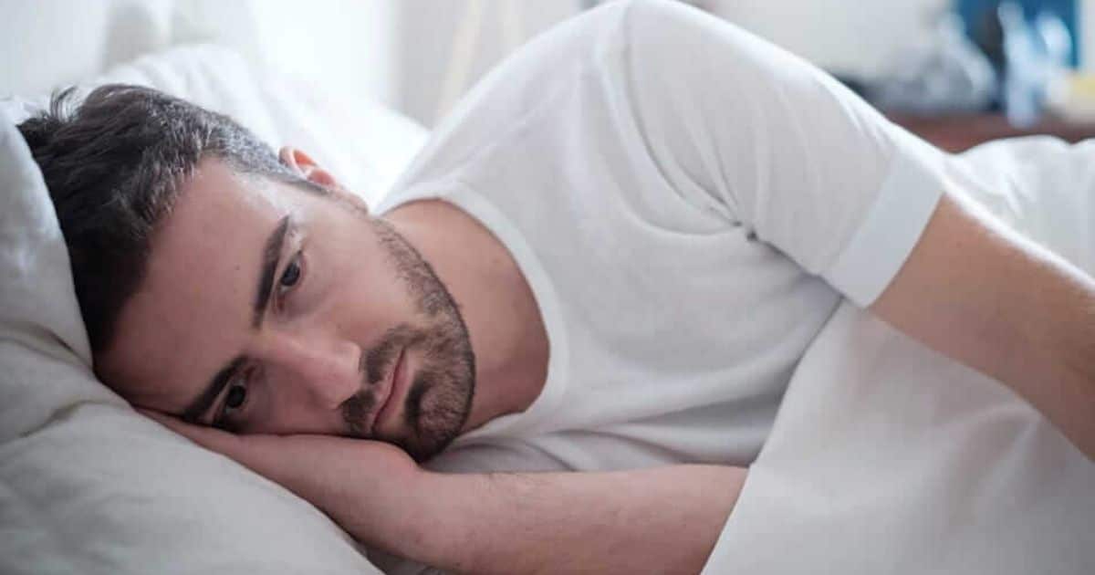Man lying awake in bed