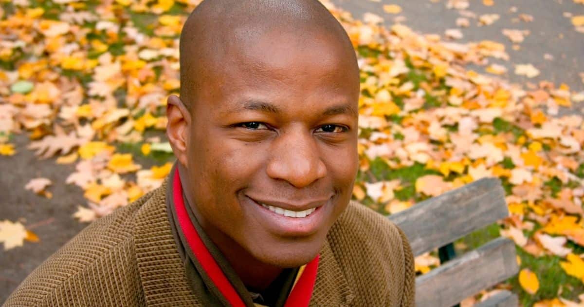 Smiling man sitting on a park bench