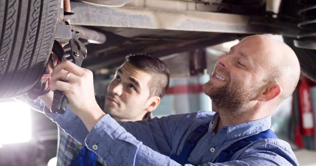 Mechanics working under a vehicle