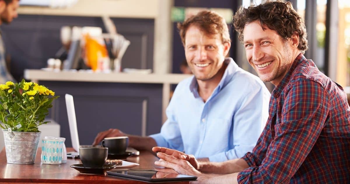 Two men laughing together at a table