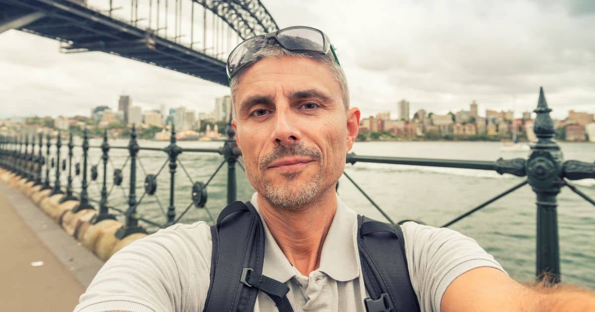 Man taking a selfie near a city waterfront