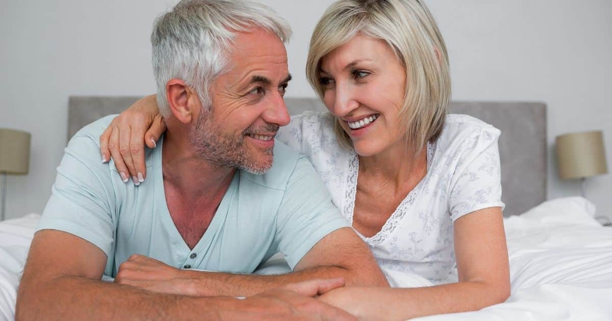 Older couple smiling together in bed