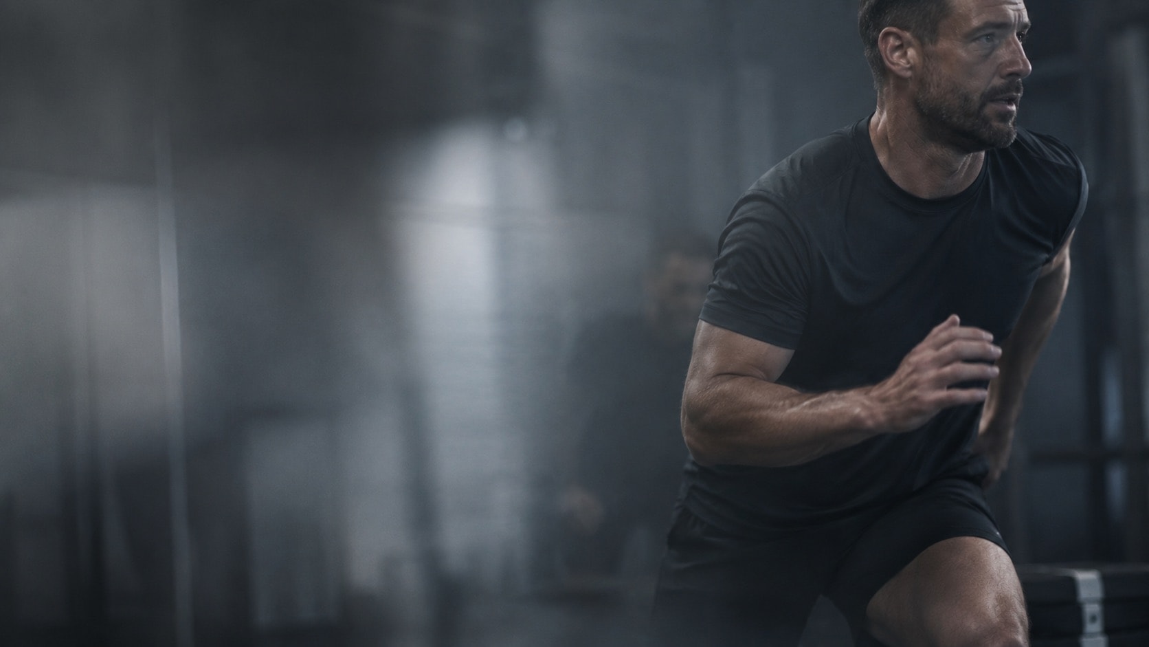Man training at pace in a low-lit gym