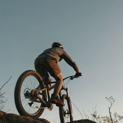 Man riding a mountain bike over a ridge