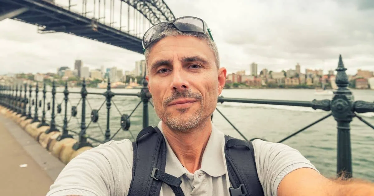 Man taking a selfie near a city waterfront