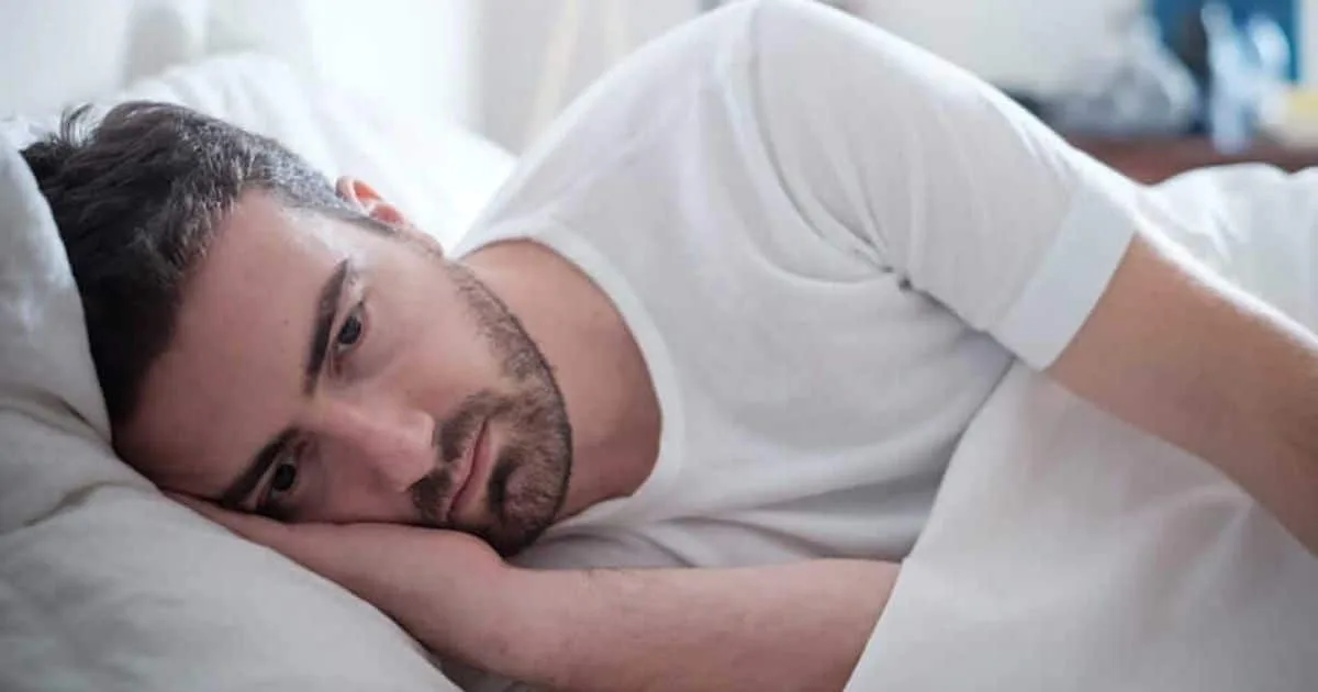 Man lying awake in bed