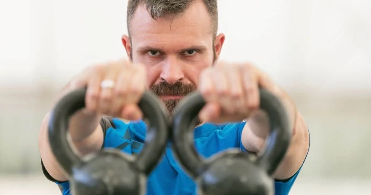 Man exercising with kettlebells
