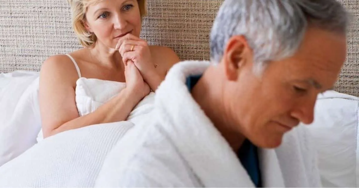 Couple in bed with man turned away