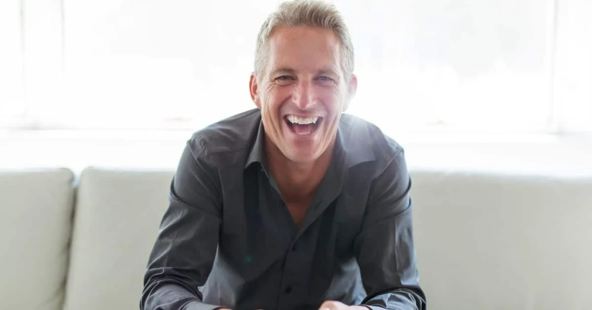 Smiling older man sitting on a couch