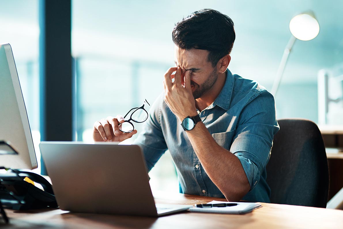 A tired man sitting at a desk