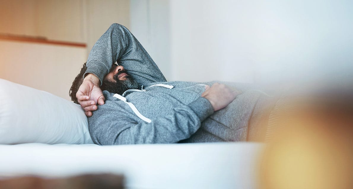 A depressed man lying in bed